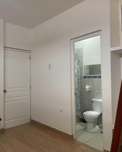 a bathroom with a toilet and a window and a door at Olas inn in Asia