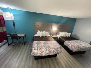 a hotel room with two beds and a desk at Jackson Motel in Murfreesboro