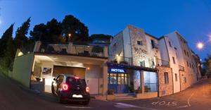 a car parked in front of a building on a street at Hotel Bia Maore in Baunei