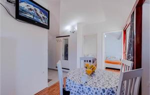 a dining room with a table and chairs and a television at Apartments Niks - terrace & sea view in Vela Luka