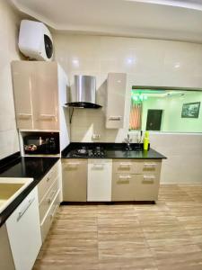 a kitchen with white cabinets and a black counter top at Birchwood 1 in Abuja