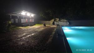 a swimming pool at night with a lit up building at Talula Hill Farm Resort in Kluang