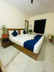 a bedroom with a large bed with blue and white sheets at Hotel KP Suites Airport in Shamshabad