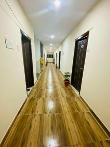 an empty corridor of an office with wooden floors and doors at Hotel KP Suites Airport in Shamshabad