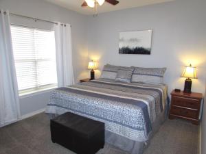 een slaapkamer met een bed, 2 lampen en een raam bij Condo B-4 near Table Rock Lake in Hollister