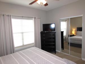 a bedroom with a bed and a tv and a mirror at Walk-in level Condo B-6 Near Lake in Hollister
