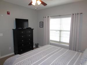 a bedroom with a bed and a television and a window at Walk-in level Condo B-6 Near Lake in Hollister