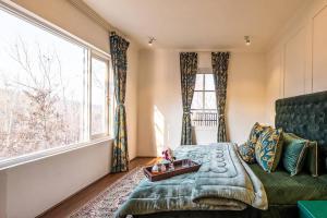 1 dormitorio con cama verde y ventana grande en Nazm Villa en Gulmarg