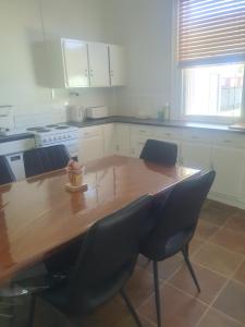 a kitchen with a wooden table and two chairs at Balranald Motor Inn in Balranald