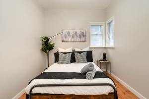 a white bedroom with a bed with pillows at La Maison in Vancouver