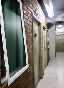 einen Flur mit Ziegelwand und Fenster in der Unterkunft BRICKS Cameron Hostel in Tanah Rata