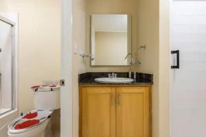 ein Badezimmer mit einem Waschbecken, einem WC und einem Spiegel in der Unterkunft Villa Portes Pop in San Felipe de Puerto Plata