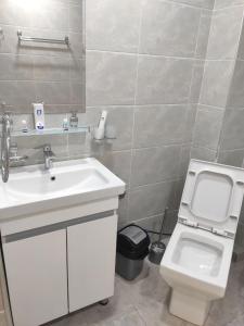 STATUS HOTEL في قرشي: حمام مع حوض أبيض ومرحاض
