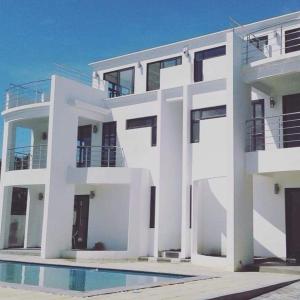 a white house with a pool in front of it at The Palm Residence in Grand-Baie