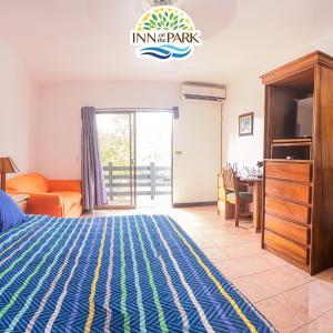 a bedroom with a bed and a desk and a table at Inn On The Park in Manuel Antonio