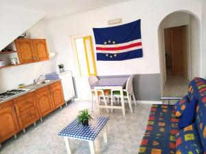 uma sala de estar com uma cozinha e uma bandeira na parede em Feeling Cabo Verde em Beirona