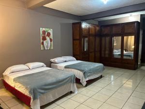 a bedroom with two beds and a mirror at Caco Historico Afrodita in Comayagua
