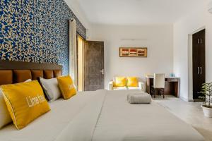 sypialnia z dużym łóżkiem z żółtymi poduszkami w obiekcie Lime Tree Hotel - Golf Course Road, Sector-43, Gurugram w mieście Gurgaon