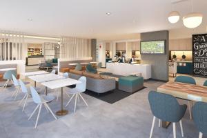TownePlace Suites by Marriott Geneva at SPIRE Academy في Geneva: مطعم بطاولات وكراسي في كفتريا