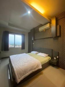 Schlafzimmer mit einem großen Bett und einem Fenster in der Unterkunft Apartement Studio The Edge Baros by Sky in Cimindi