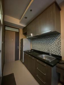 eine Küche mit einer Spüle und einem Kühlschrank in der Unterkunft Apartement Studio The Edge Baros by Sky in Cimindi