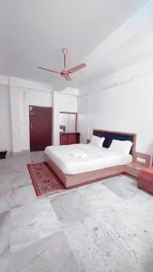 1 dormitorio con 1 cama y ventilador de techo en SM LODGE and RESTAURANT, en Guwahati