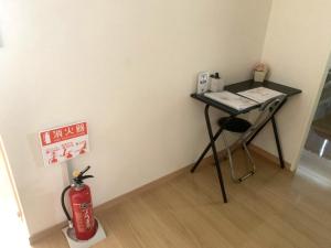 una camera con scrivania e idrante accanto a un muro di 麗base野芥 a Fukuoka