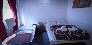 two twin beds in a room with a window at The FnF Resort & Camping - Rishikehs in Rishīkesh