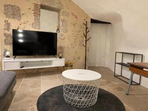 sala de estar con TV y mesa en Troglodyte d’exception au cœur de Blois en Blois