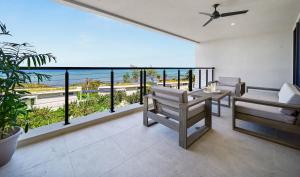 um quarto com uma varanda com vista para o oceano em VIDA Cayman em West Bay