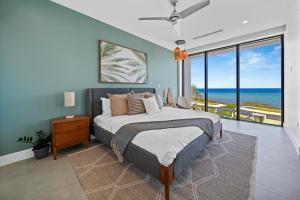 a bedroom with a bed with a view of the ocean at VIDA Cayman in West Bay
