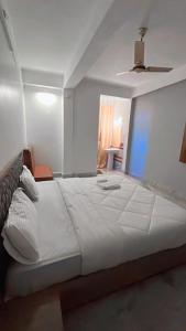 uma grande cama branca num quarto com tecto em SM LODGE and RESTAURANT em Guwahati