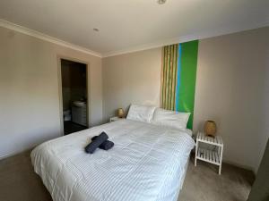 a bedroom with a white bed with a blue towel on it at Elegant 2 Bedroom home close to city buz Bridge RD 2 E-Bikes Included in Sydney