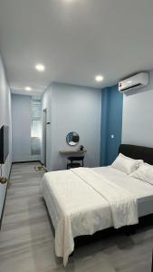 um quarto com uma cama branca e uma parede azul em Good Night BD Motel 
