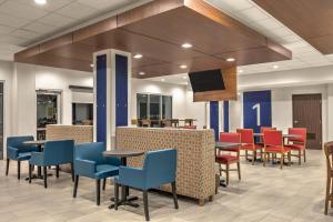 a lobby with tables and chairs and a tv at Holiday Inn Express - San Antonio East I-10 , an IHG Hotel in San Antonio