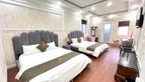- une chambre avec 2 lits et une télévision dans l'établissement BÔNG SEN HOTEL CÔN ĐẢO, à Côn Son