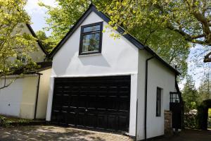 a white house with a black garage at 'Lady Hall' Guest House in Trotterscliffe