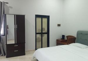 ドゥングンにあるAdamia Roomstay in Dungunのベッドルーム1室(ベッド1台、ドレッサー、鏡付)
