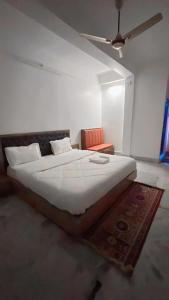 1 dormitorio con 1 cama grande y ventilador de techo en SM LODGE and RESTAURANT en Guwahati