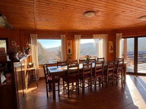 a dining room with a large wooden table and chairs at Cabana Craiu Garana in Gărâna