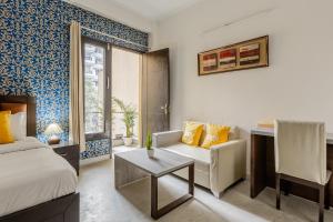 um quarto com uma cama, um sofá e uma mesa em Lime Tree Hotel - Golf Course Road, Sector-43, Gurugram em Gurgaon