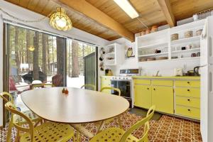 a kitchen with yellow cabinets and a table and chairs at Quail's Call Big Bear~ Walk to Lake & Ski Resort in Big Bear Lake +9 photos