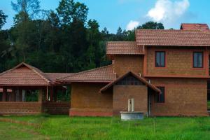 a brick house with a red roof at HighFields Coorg in Virajpet +17 photos