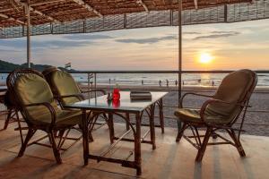a table and chairs with a view of the beach at Agonda Cottages in Agonda