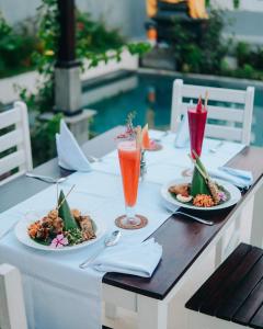 Una mesa con platos de comida y bebidas sobre ella. en Private villa bamboo cozy, en Lovina
