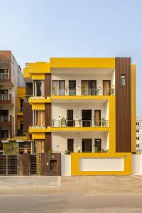 a yellow and white building with balconies on it at Lime Tree Hotel - Golf Course Road, Sector-43, Gurugram in Gurgaon