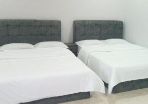 two beds sitting next to each other in a room at Adamia Roomstay in Dungun 01 in Dungun