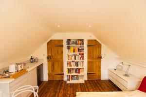 a kitchen with a book shelf with books at 'Lady Hall' Guest House in Trotterscliffe
