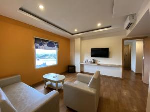 a living room with a couch and a tv at Front One Budget Malang by Azana in Malang