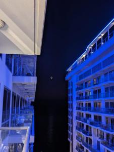 a view of two tall buildings with blue lights at Marjan Island Beautiful Apartment Sea View Beach Luxury Rooms Ras Al Khaimah UAE in Ras al Khaimah